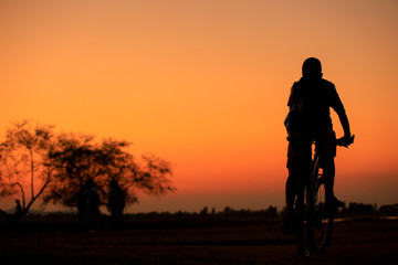 Fototapeta na wymiar Silhouette of a cyclist and sunset