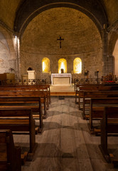 VERTICAL: Beautiful shot of an altar and benches inside an empty Catholic church