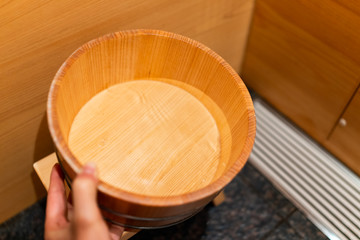 Cypress bathtub wooden traditional Japanese bucket by water stool in onsen hotel bathroom interior in Japan