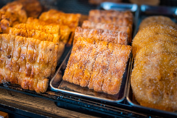 Closeup of many dessert pastries with sugar on shelf tray display desserts in bakery shop cafe store counter in Takayama, Gifu Prefecture in Japan