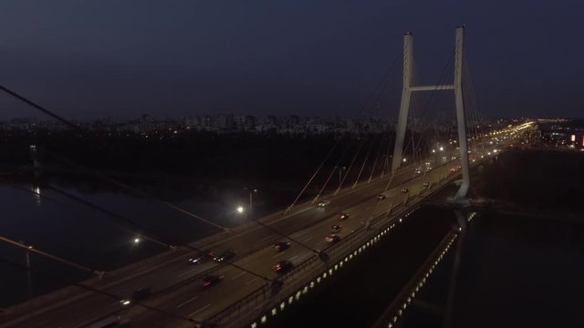 Aerial view of the illuminated night Siekierkowski Bridge crossing the Vistula River in Warsaw Poland.