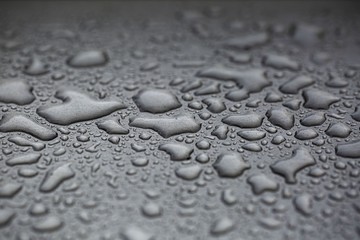 Beautiful background texture of rain water drops on grey black metal surface. Beautiful backgrounds.