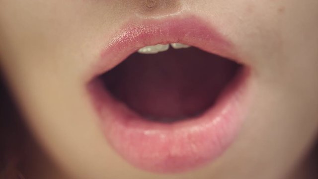 Female face of attractive woman with opened mouth. Sexy and plump female lips