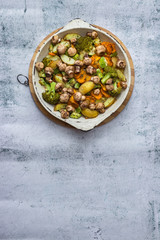 Baked, roasted, grilled vegetables in skillet on white marble background with space for text. Vegan, vegetarian healthy food.