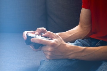 Young man playing video games at night using a gamepad