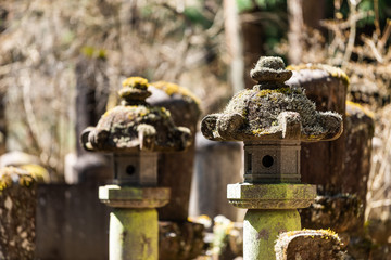 Famous cemetary in Kanmangafuchi Abyss, Nikko, Tochigi in Japan with path closeup of stone lanterns and grave during day