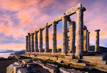 Sounion, Attica / Greece. The Temple of Poseidon at cape Sounion. Colorful sunset with beautiful cloudy sky. Golden hour