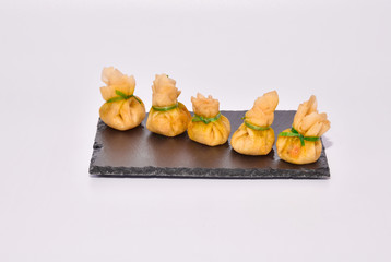 Delicious shrimp dumpling lined up on a black slate