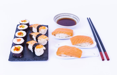 Sushi rolls, Salmon sushi roll, soy sauce, white rice, chopsticks and a white background