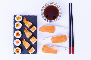 Sushi rolls, Salmon sushi roll, soy sauce, white rice, chopsticks and a white background