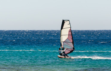 young surfer girl rides a sail in the Red Sea in Egypt Dahab