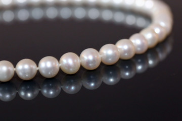 Pearl necklace on black background