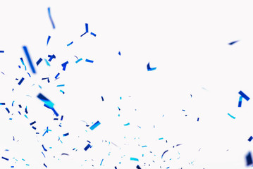 Confetti from crackers. Blue elements on a white background. Shot of confetti at a party. Festive mood. Serpentine, festive decor - obrazy, fototapety, plakaty