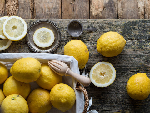From above lemons and citrus reamer placed on wooden board