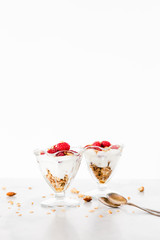Fresh Raspberries on Top of Granola and Yogurt Parfait On Light Background, Space For Text