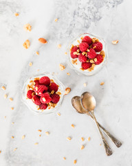 Fresh Raspberries on Top of Granola and Yogurt Parfait On Light Background Top View