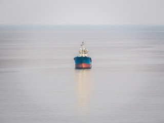 The cargo ship is traveling in the ocean.
