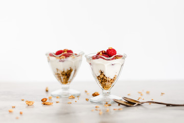 Fresh Raspberries on Top of Granola and Yogurt Parfait On Light Background