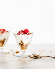 Fresh Raspberries on Top of Granola and Yogurt Parfait On Light Background, Space for Text