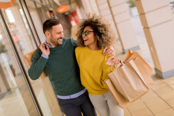 Beautiful young multiethnic couple enjoying in shopping, having fun in the city