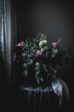 Amazing bouquet of flowers on a table into a dark vintage room