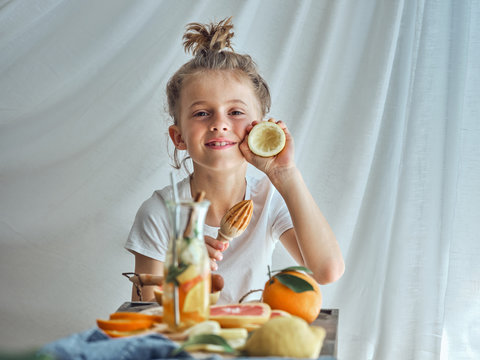 Funny boy holding in hands wooden reamer and peel of lemon after pressing juice for lemonade
