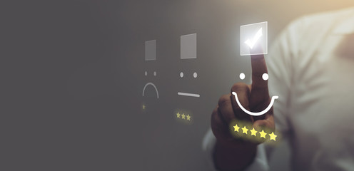 Businessman pressing smiley face emoticon on virtual touch screen. Customer service evaluation...