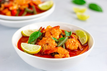 Thai Shrimp Red Curry in the Bowls with Chopsticks Served with Basil and Lemon on White Background. Thai Food, .Oriental Food, Asian Food, Thai Cuisine Concept.