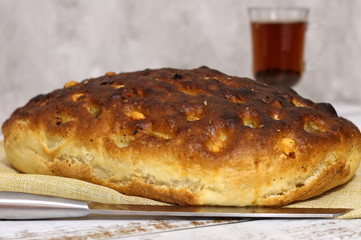 Italian bread with cheese, tomatoes and herbs. Focaccia on the table.