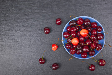 Various summer Fresh Cherry in a bowl on rustic wooden table. .Antioxidants, detox diet, organic fruits. Top view. Berries