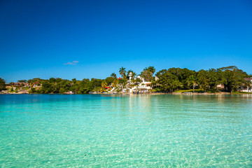 Laguna de Bacalar aka as the Lagoon of Seven Colors, Mexico. The crystal clear waters and white sandy bottom of the lake cause the water color to morph into varying shades of turquoise and blue.