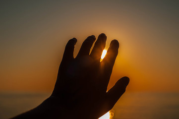 silhouette hands against the sun