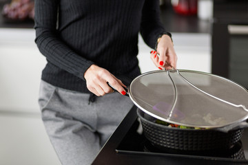The girl prepares food in the kitchen. Hands close-up