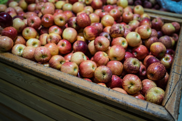 Ripe apple in wooden box Fresh striped apples in wooden box with straw