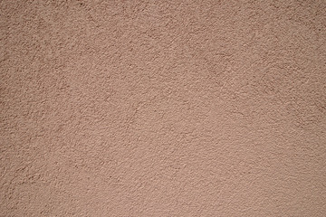 Peach plastered wall in sunlight. Modern building materials for