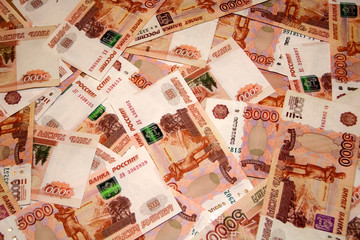 Banknotes of Russian currency face value of 5,000 rubles scattered on the table are a sign of...