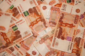 Banknotes of Russian currency face value of 5,000 rubles scattered on the table are a sign of riches and prosperity.
