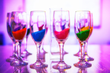 glasses with colored sand are on the table