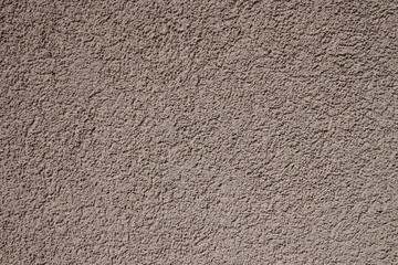 Plastered cocoa-milk wall in sunlight. Modern building materials