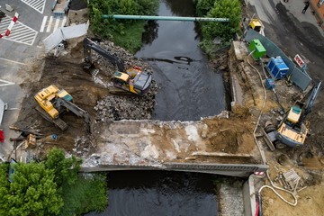 Drone view on excavators demolishing a road bridge.
