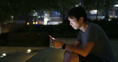 Man use of mobile phone in city at night