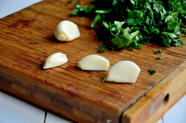 Garlic, parsley on a cutting board.