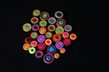 Colourful paper quilled tight coil circles against black background