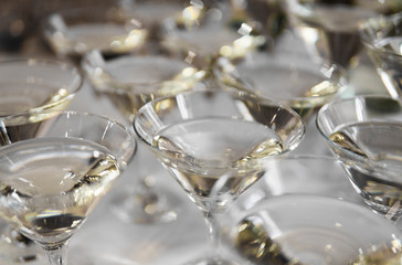 Alcohol cocktails, martini, vodka and others on decorated catering bouquet table on open air event or wedding.