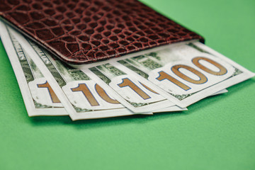Leather wallet with money on a wooden background.