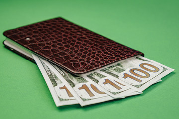 Leather wallet with money on a wooden background.
