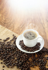 Coffee cup and roasted coffee beans. on wooden background.
