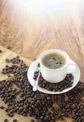 Coffee cup and roasted coffee beans. on wooden background.