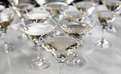 Alcohol cocktails, martini, vodka and others on decorated catering bouquet table on open air event or wedding.