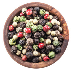 Colorful peppercorns in wooden bowl on white background. Clipping path.